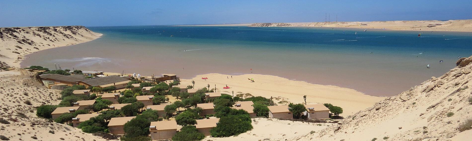 Küstenresort in Dakhla, Ocean Vagabond, an einem Strand mit Blick auf ruhiges, blaues Wasser und Sanddünen.