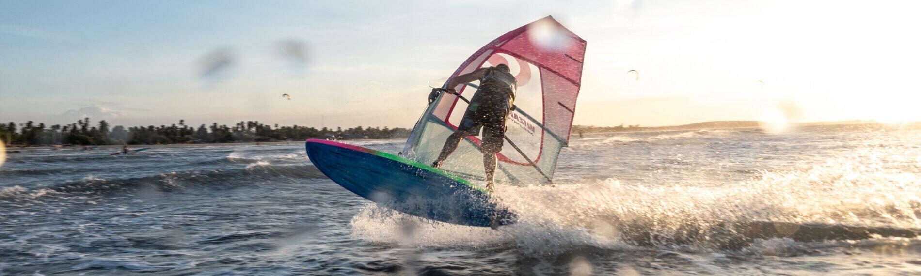 Windsurfer bei Sonnenuntergang auf dem Meer in Maceio, Brasilien