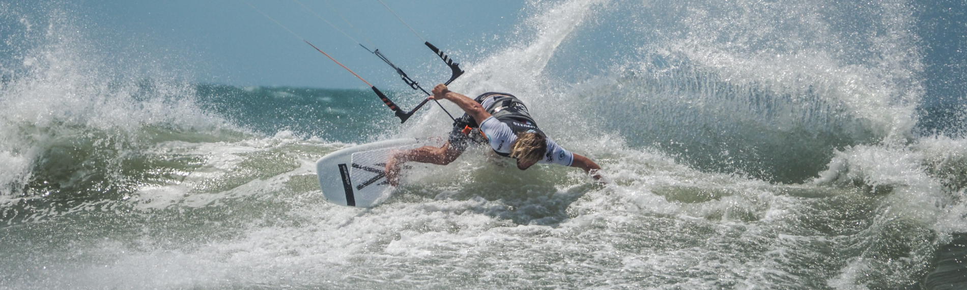 Kitesurfer gleitet in Maceio auf Wellen bei starkem Wind.